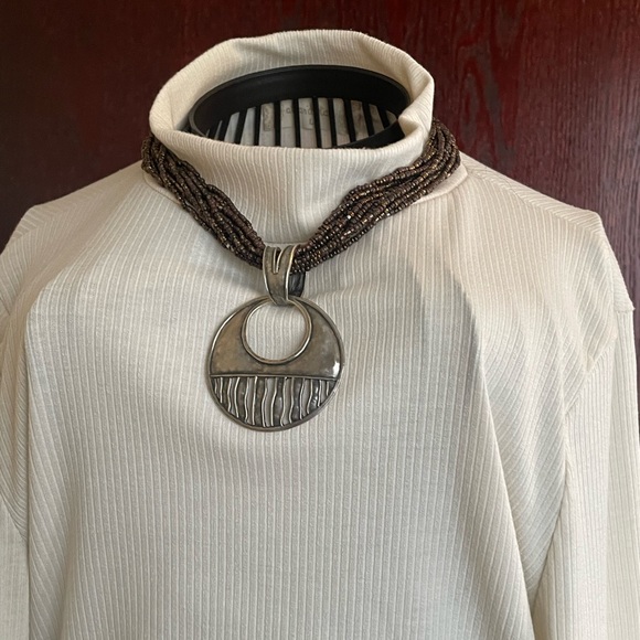 Jewelry - Make a statement with this twisted beaded necklace that has this unique pendant.